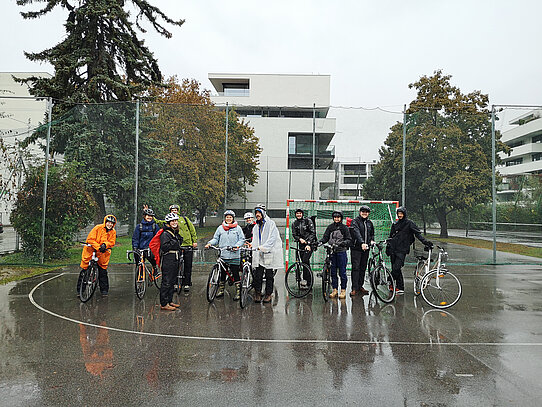 lachende neue Radfahrtrainerinnen und Radfahrtrainer im Regen